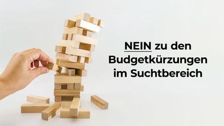 Eine Hand zieht ein Holzstück aus einem schiefen Jenga-Turm.